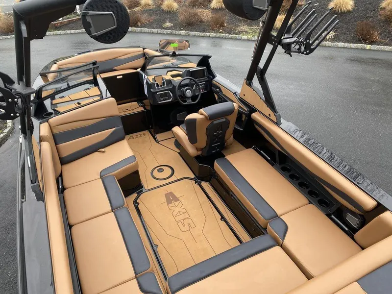 Slide: The Image of 2025 Axis A225 boat interior with tan and black seating, sleek design, and modern dashboard. - 8