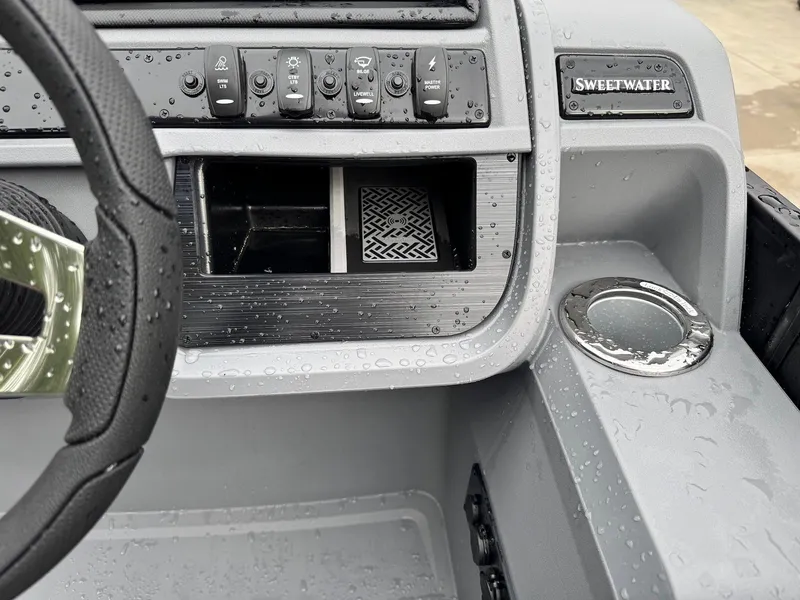 Slide: The Image of 2025 Godfrey Sweetwater 2286 SFLC dashboard with controls and cup holder, wet from rain. - 28