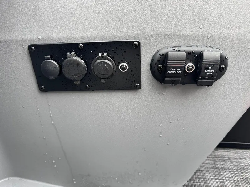 Slide: The Image of Control panel on a 2025 Godfrey Sweetwater 2286 SFLC boat, featuring various switches and outlets. - 29