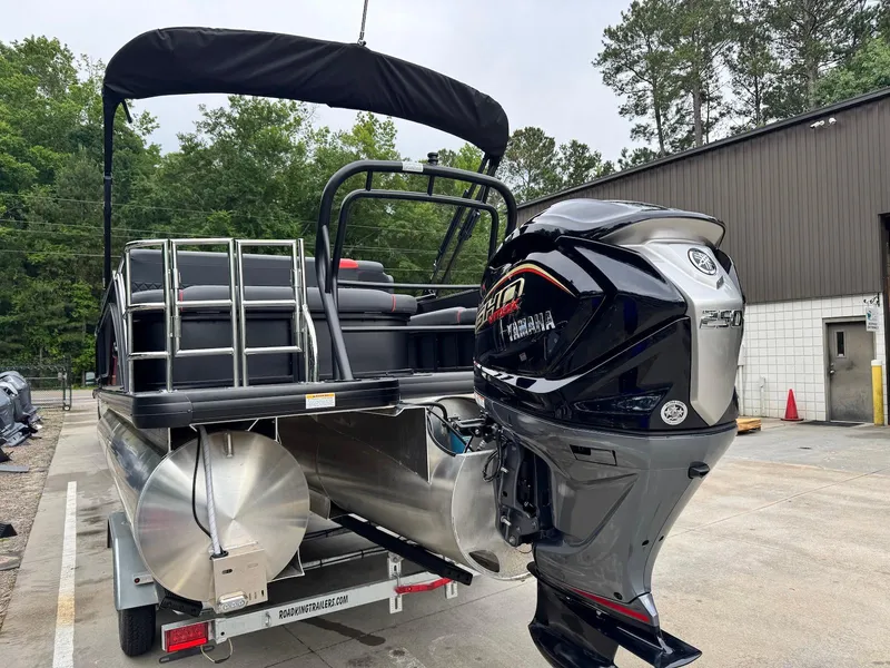 Slide: The Image of 2025 Godfrey Sweetwater 2286 SFLC pontoon boat with Yamaha 250 engine, parked outdoors. - 4