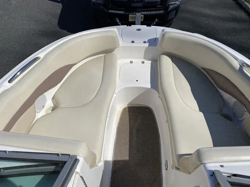 Slide: The Image of 2005 Chaparral 216 Sunesta boat interior with beige seating and carpeted floor. - 13