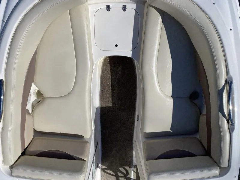 Slide: The Image of 2005 Chaparral 216 Sunesta boat interior with white seating and storage compartment. - 14