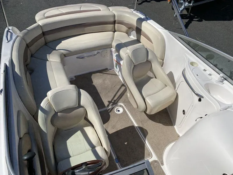 Slide: The Image of 2005 Chaparral 216 Sunesta boat interior with beige seating and steering wheel. - 16