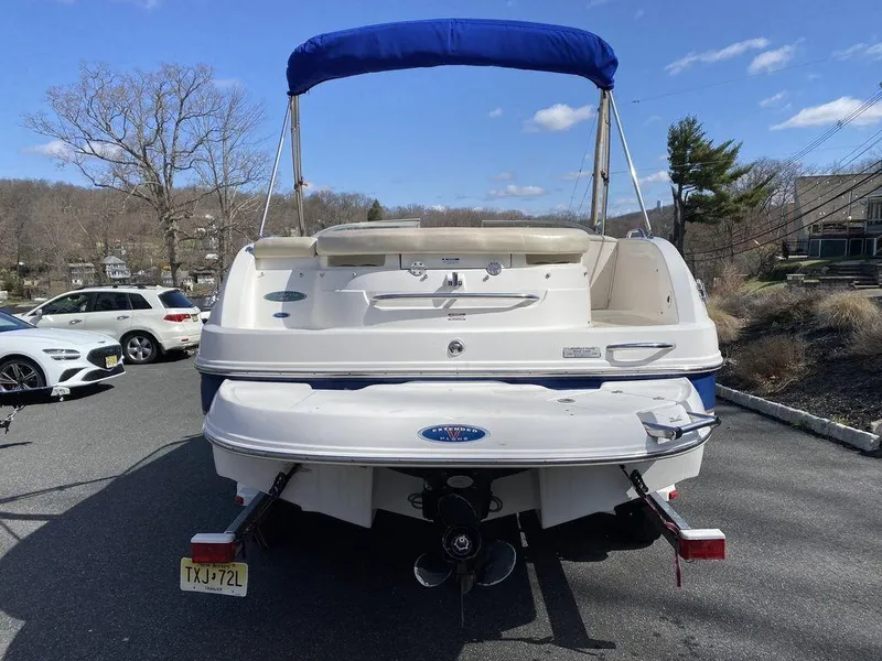 Slide: The Image of 2005 Chaparral 216 Sunesta boat with blue canopy, parked on a sunny day. - 4