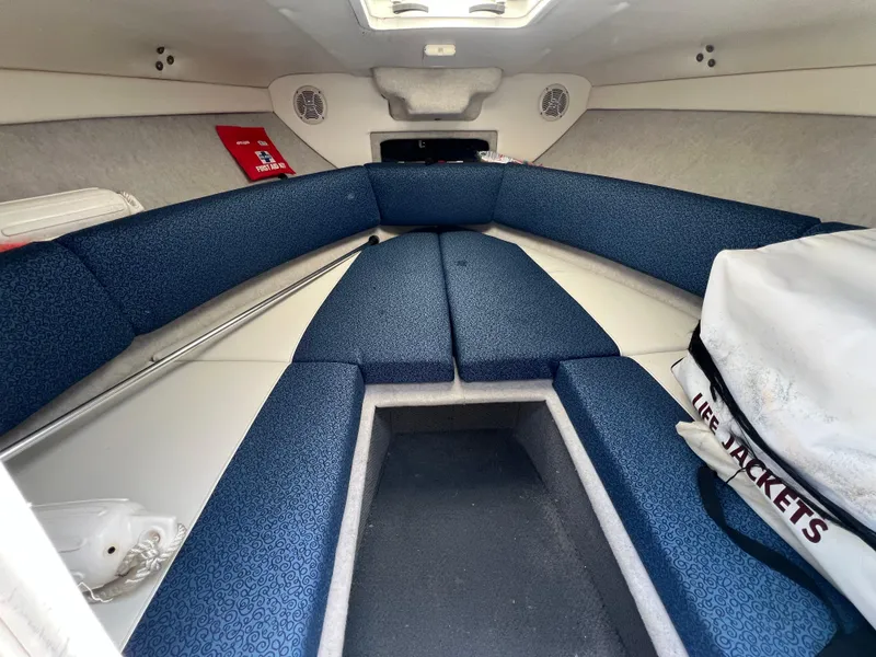 Slide: The Image of 2006 Bayliner 212 boat interior with blue seating and life jackets. - 3