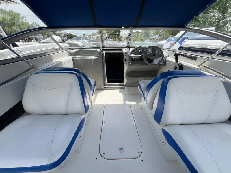 Slide: The Image of Interior of a 2006 Bayliner 212 boat with white and blue seating. - 4