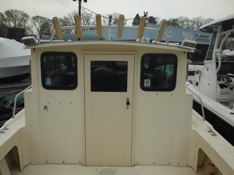 Slide: The Image of 2002 Parker 2520 Modified Vee Sport Cabin boat with rod holders and cabin windows. - 17