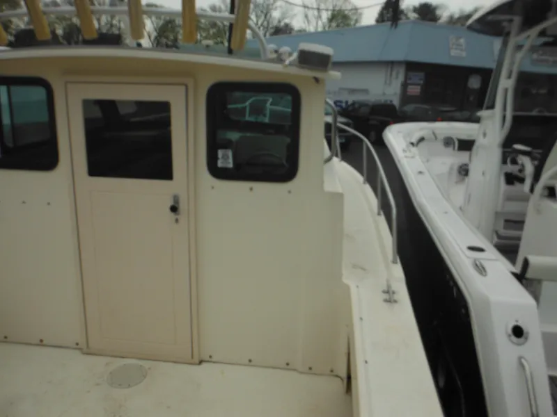Slide: The Image of 2002 Parker 2520 Modified Vee Sport Cabin boat, docked beside another vessel. - 18