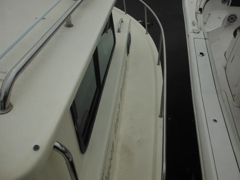Slide: The Image of 2002 Parker 2520 Modified Vee Sport Cabin boat docked beside another vessel. - 21