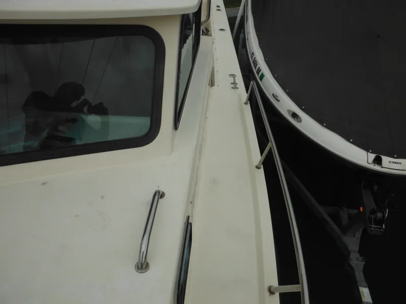 Slide: The Image of 2002 Parker 2520 Modified Vee Sport Cabin boat docked beside another vessel. - 26