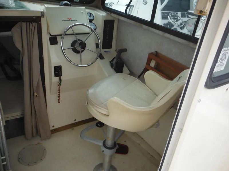 Slide: The Image of 2002 Parker 2520 Modified Vee Sport Cabin interior with steering wheel and captain's chair. - 28