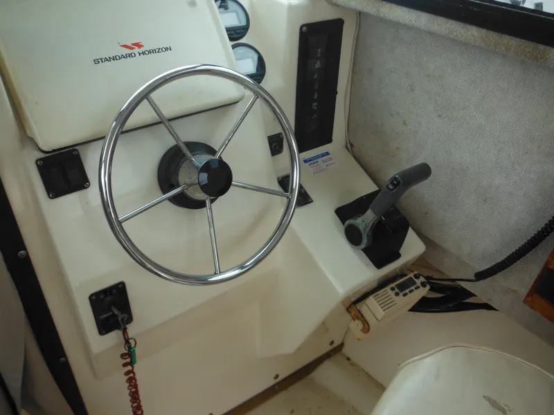 Slide: The Image of Steering wheel and controls of a 2002 Parker 2520 Modified Vee Sport Cabin boat. - 31