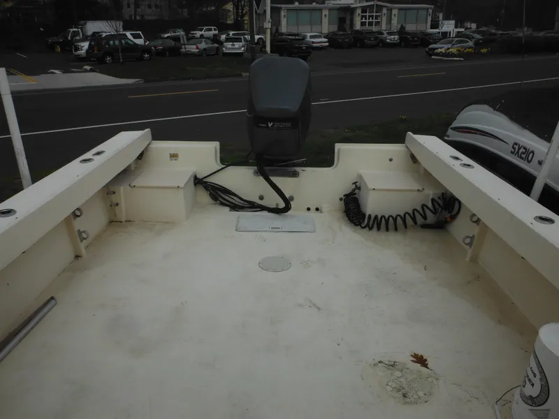 Slide: The Image of 2002 Parker 2520 Modified Vee Sport Cabin boat deck with motor, docked near road. - 42