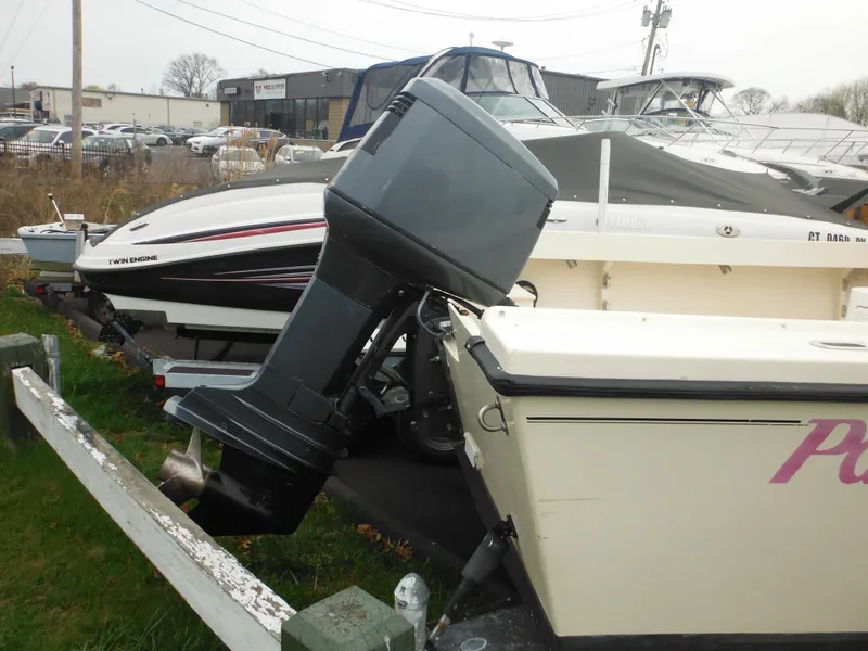 Slide: The Image of 2002 Parker 2520 Modified Vee Sport Cabin boat with outboard motor in a storage area. - 7