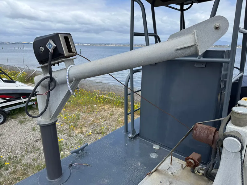 Slide: The Image of 2004 SeaArk 35 Aluminum Work Boat with A-Frame, docked near a coastal area. - 10