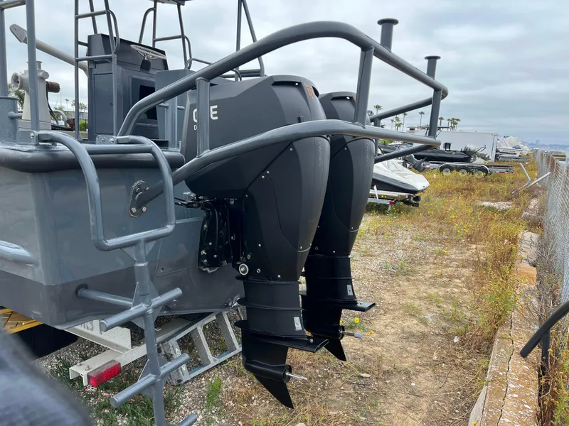 Slide: The Image of 2004 SeaArk 35 Aluminum Work Boat with A-Frame, dual outboard motors, docked on land. - 2