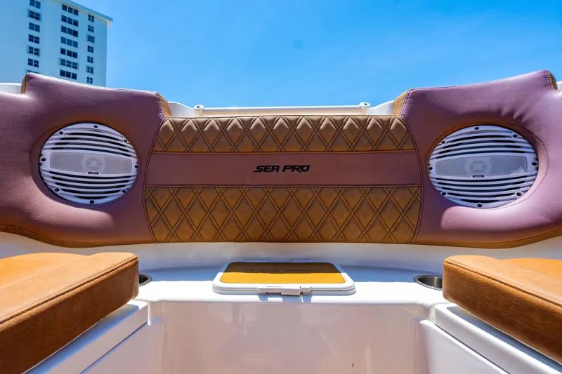 Slide: The Image of 2023 Sea Pro 320 DLX Offshore boat interior with speakers and cushioned seating. - 12