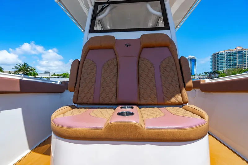 Slide: The Image of 2023 Sea Pro 320 DLX Offshore boat with luxurious seating and cup holders, under clear blue sky. - 13