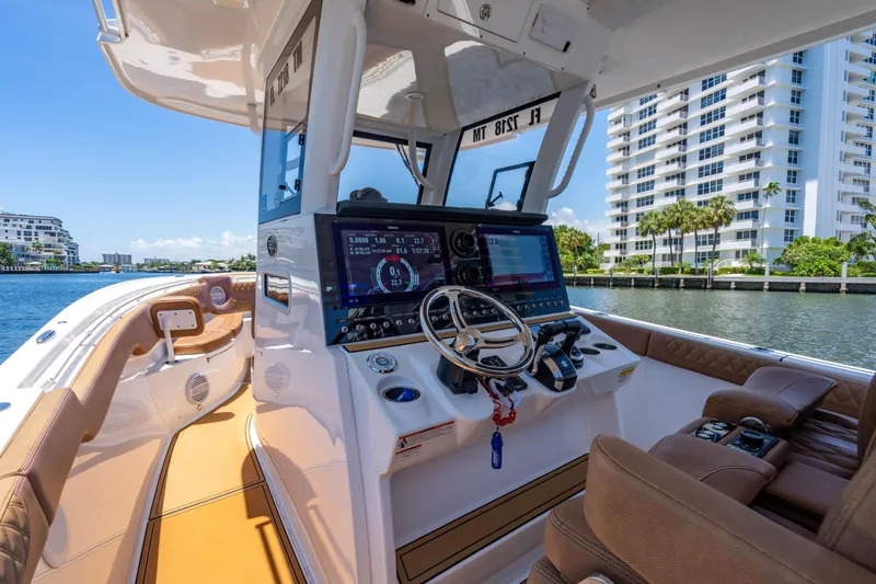 Slide: The Image of 2023 Sea Pro 320 DLX Offshore boat interior with modern dashboard and waterfront view. - 19