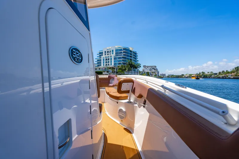 Slide: The Image of 2023 Sea Pro 320 DLX Offshore boat on sunny waterfront with modern buildings. - 29