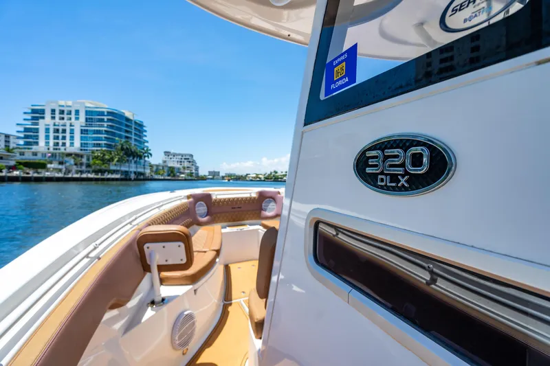 Slide: The Image of 2023 Sea Pro 320 DLX Offshore boat on water, modern design, cityscape background. - 30