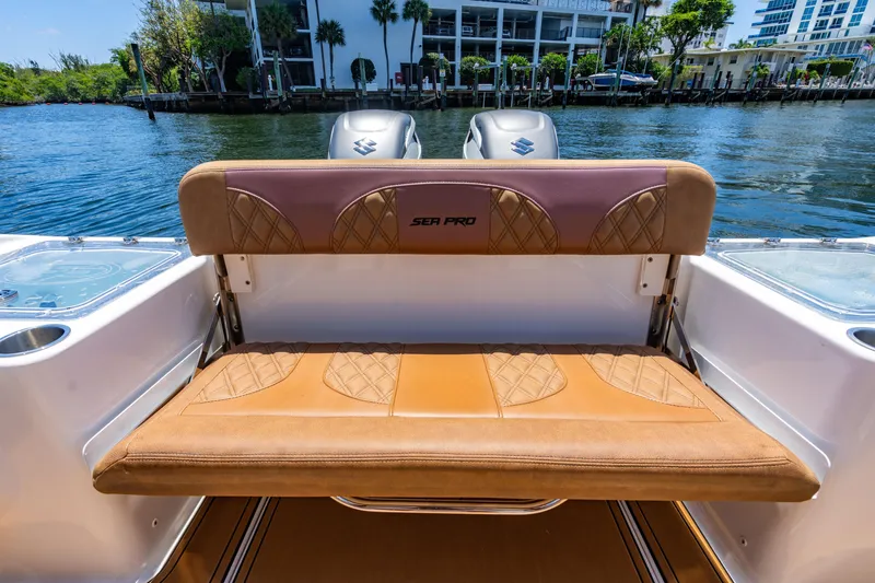 Slide: The Image of 2023 Sea Pro 320 DLX Offshore boat with tan seating, docked by the water. - 31