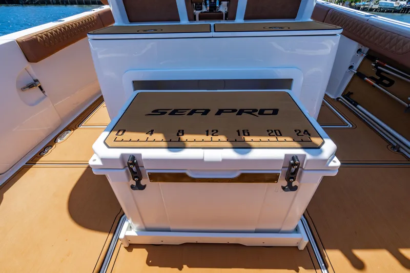 Slide: The Image of 2023 Sea Pro 320 DLX Offshore boat interior with branded cooler and measuring scale. - 35