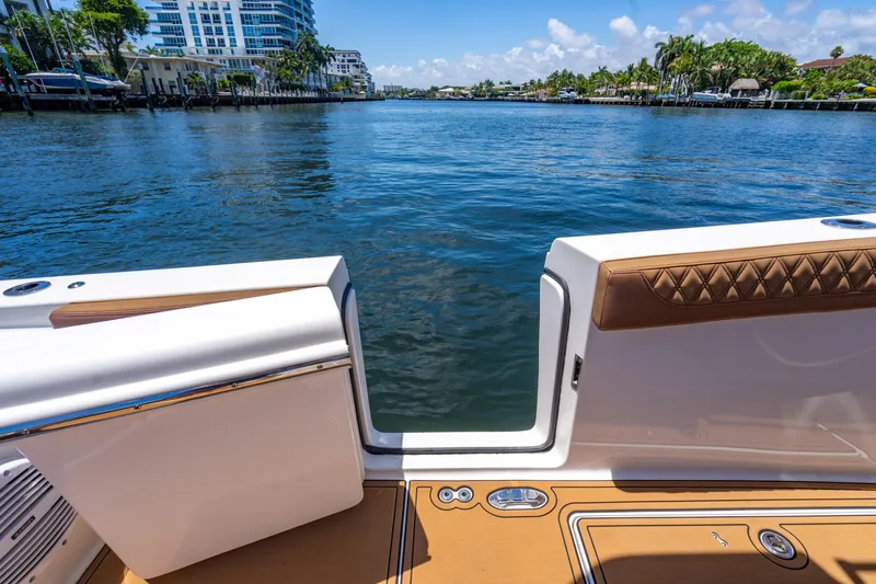 Slide: The Image of 2023 Sea Pro 320 DLX Offshore boat with open deck view on a sunny waterfront. - 40