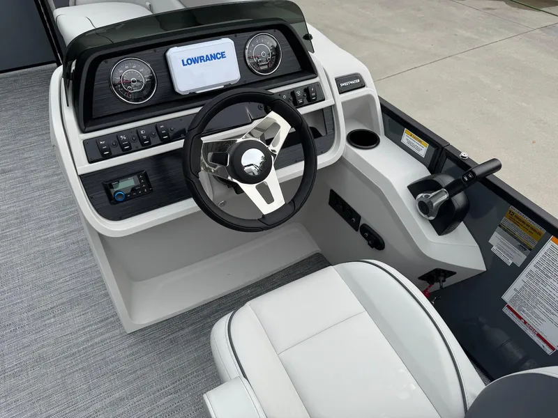 Slide: The Image of 2025 Godfrey Sweetwater 2086 SB boat helm with steering wheel and Lowrance display. - 14
