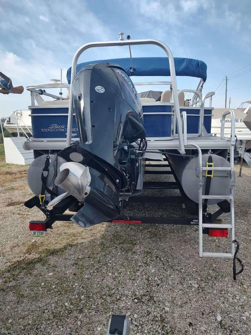 Slide: The Image of 2016 Sun Tracker Fishin' Barge 22 DLX pontoon boat with outboard motor, parked on gravel. - 7