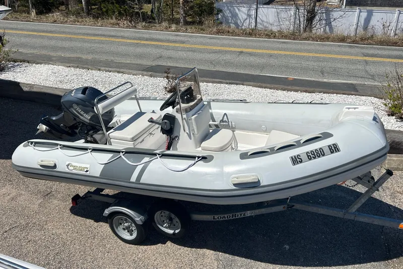 Slide: The Image of 2021 North Atlantic Inflatables RIB420 boat on trailer, parked near a road. - 7