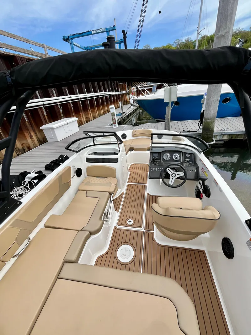 Slide: The Image of 2022 Bayliner VR5 Bowrider OB with tan seating and wood accents docked at marina. - 10