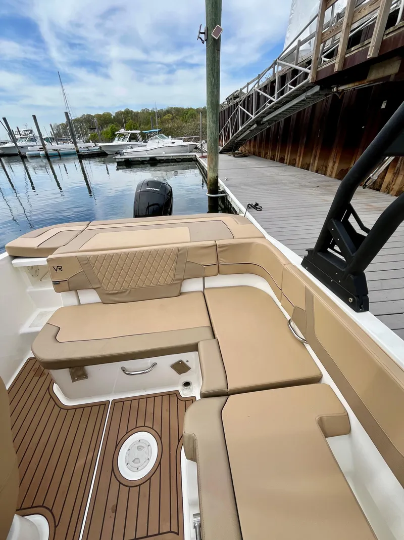 Slide: The Image of 2022 Bayliner VR5 Bowrider OB with tan seating at a marina dock. - 11