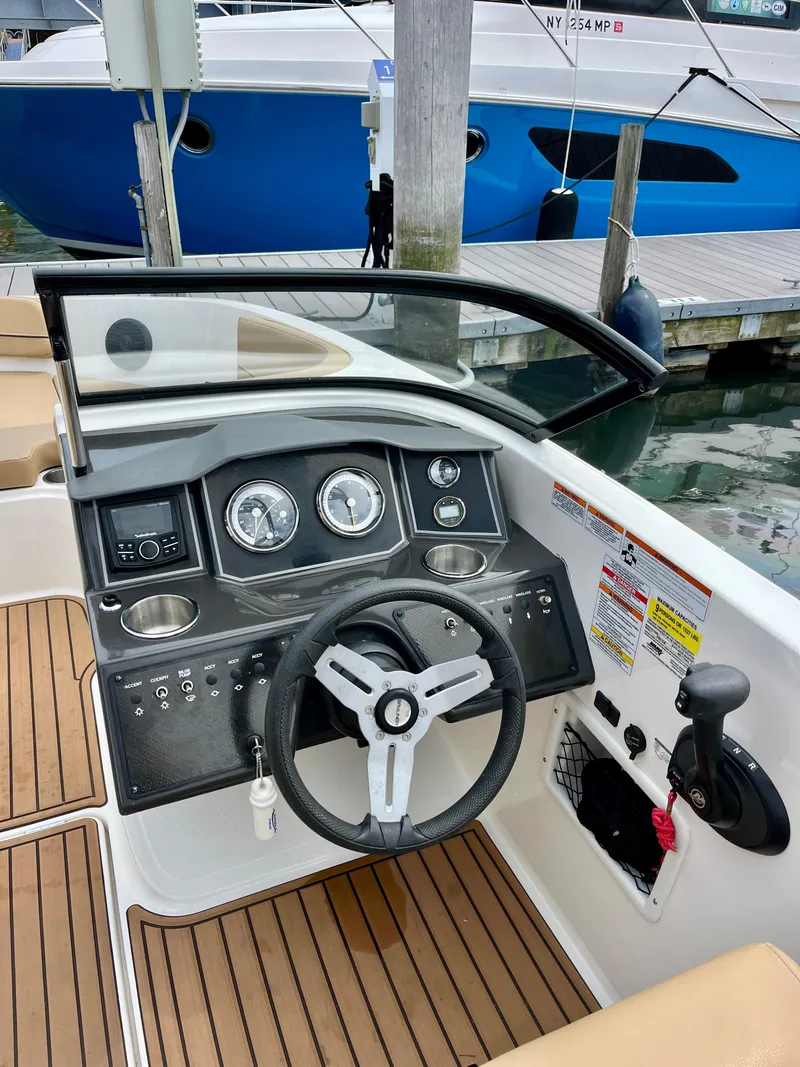 Slide: The Image of 2022 Bayliner VR5 Bowrider OB dashboard with steering wheel and controls at marina. - 12