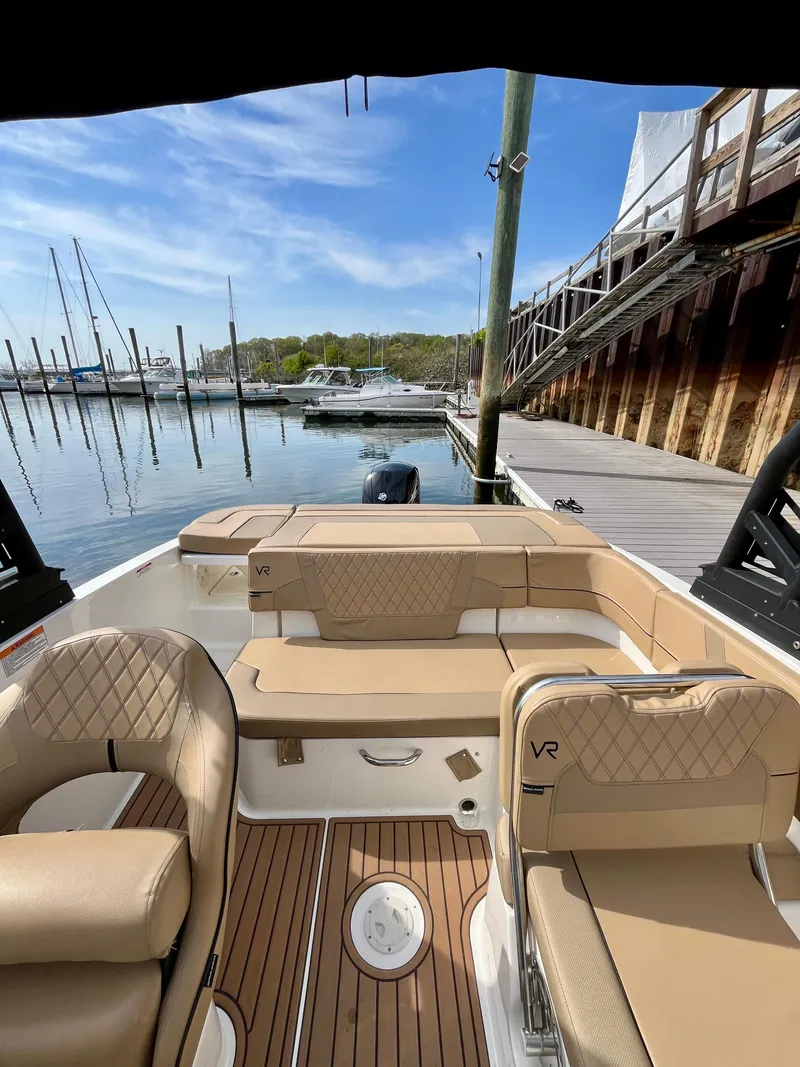Slide: The Image of 2022 Bayliner VR5 Bowrider OB with tan seating, docked at a marina under a clear sky. - 14