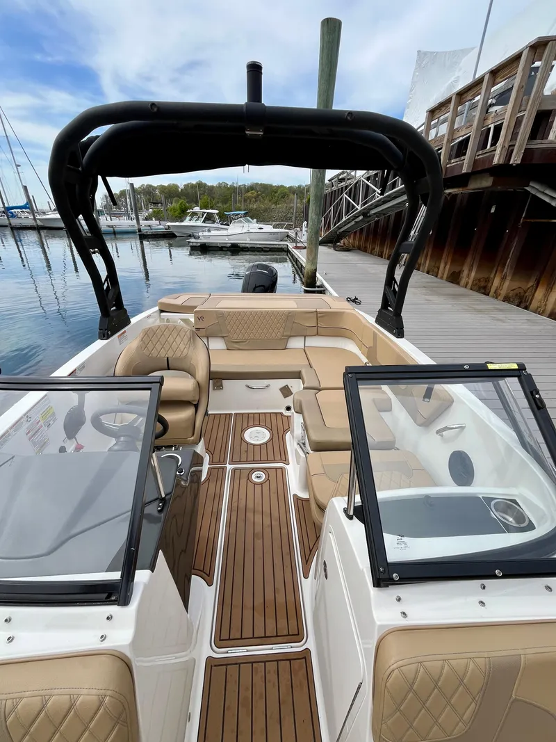 Slide: The Image of 2022 Bayliner VR5 Bowrider OB with tan seating and wood deck at marina. - 17
