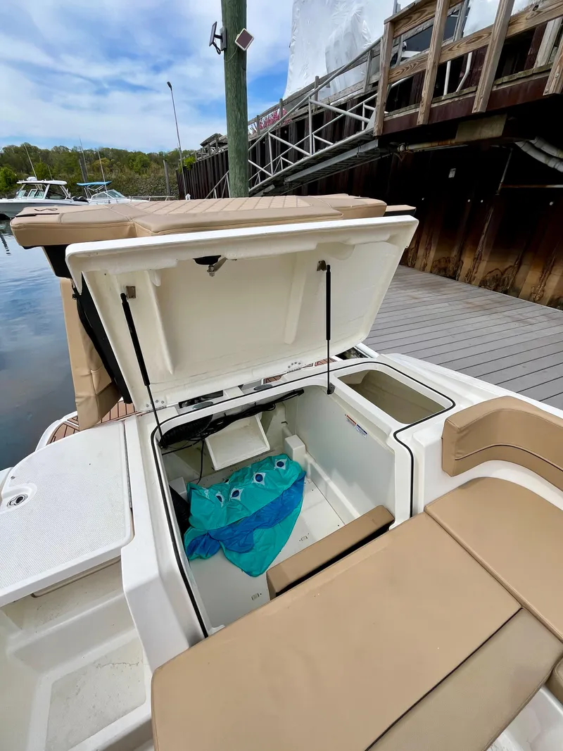 Slide: The Image of 2022 Bayliner VR5 Bowrider OB with open storage compartment at dockside. - 18
