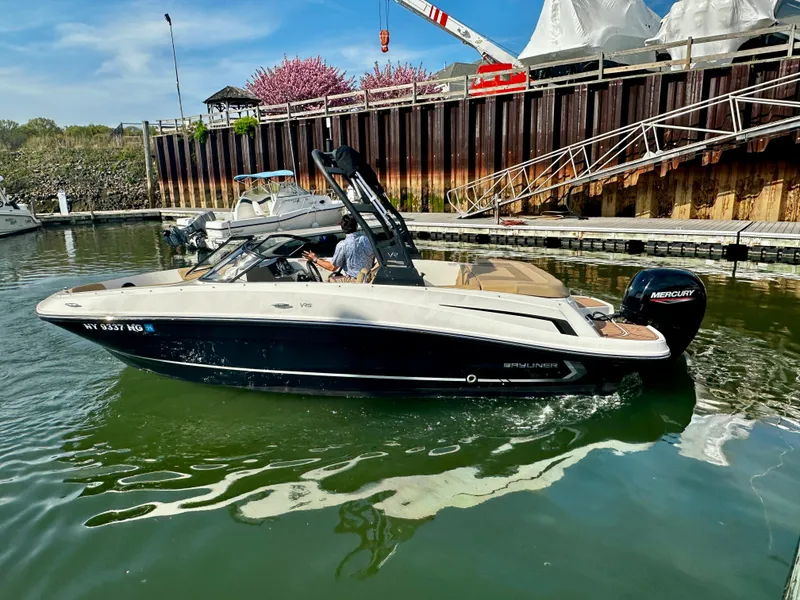 Slide: The Image of 2022 Bayliner VR5 Bowrider OB in marina, side view, with Mercury outboard engine. - 2