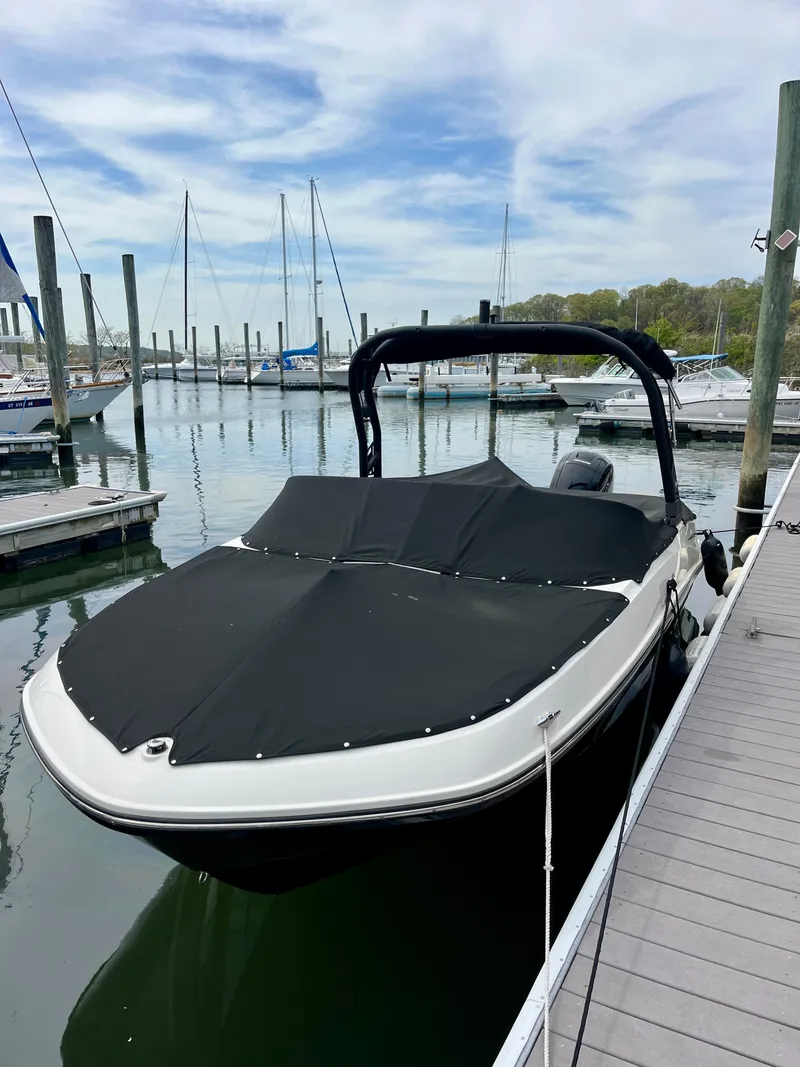 Slide: The Image of 2022 Bayliner VR5 Bowrider OB docked at a marina with a black cover. - 20
