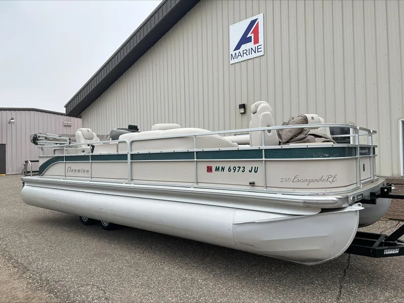 Slide: The Image of 2003 Premier 250 Escapade pontoon boat parked outside a marine facility. - 2