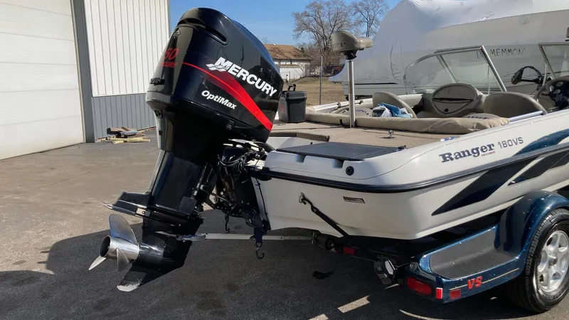 Slide: The Image of 2004 Ranger 180 Reata boat with Mercury Optimax outboard motor, parked outdoors. - 1