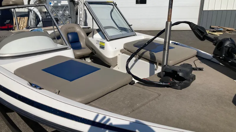 Slide: The Image of 2004 Ranger 180 Reata boat interior with seating and steering wheel, parked outdoors. - 8