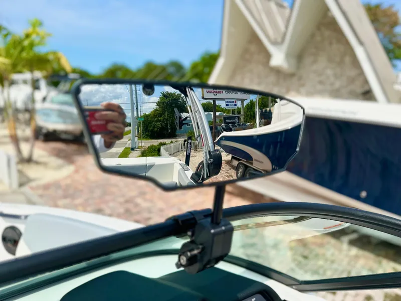 Slide: The Image of 2023 MasterCraft NXT21 boat mirror reflecting outdoor scene with trees and buildings. - 15