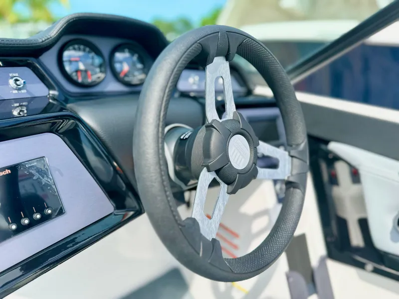 Slide: The Image of 2023 MasterCraft NXT21 boat steering wheel and dashboard close-up. - 25