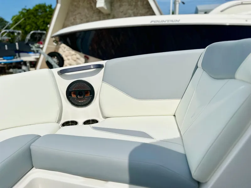 Slide: The Image of 2023 MasterCraft NXT21 boat interior with white and gray seating, speaker, and cup holders. - 28