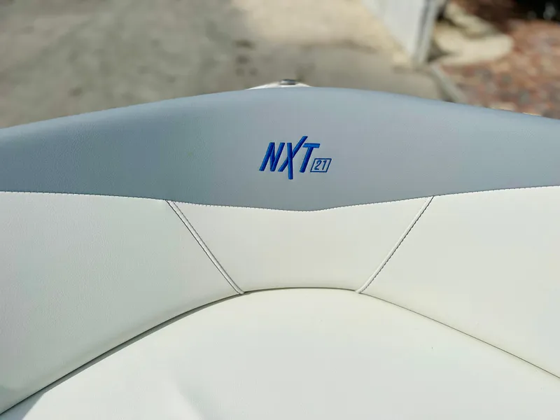 Slide: The Image of 2023 MasterCraft NXT21 boat seat with logo, featuring white and gray upholstery. - 30