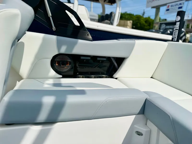Slide: The Image of 2023 MasterCraft NXT21 boat interior with white and gray seating, speaker detail. - 33