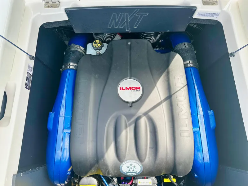 Slide: The Image of 2023 MasterCraft NXT21 Ilmor engine with blue accents in boat compartment. - 36