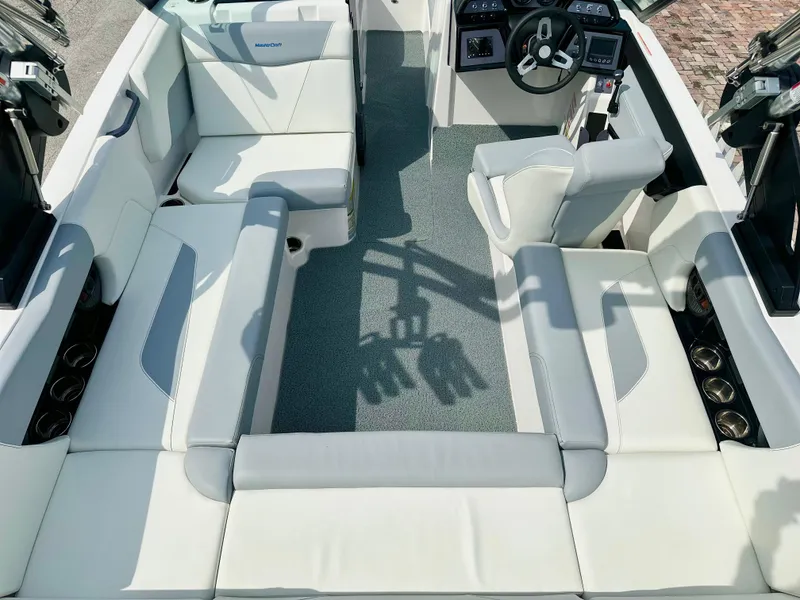 Slide: The Image of 2023 MasterCraft NXT21 boat interior with white seating and modern dashboard. - 37