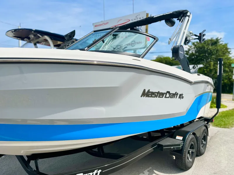 Slide: The Image of 2023 MasterCraft NXT21 boat on trailer, featuring sleek design and blue accents. - 40